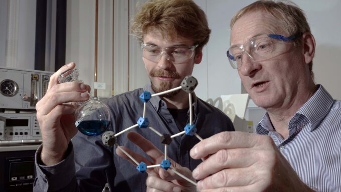 PhD student Benjamin Kintzel (l.) and Prof. Dr Winfried Plass discuss a molecule they have developed, that may possibly be used in a quantum computer.