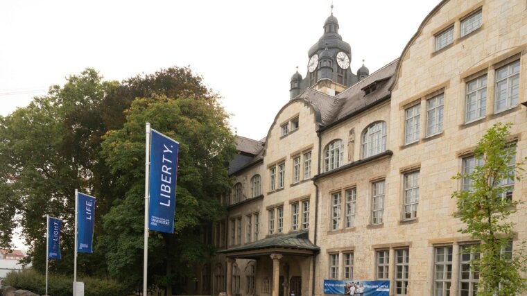 Fahnen mit dem Slogan "Light, Life, Liberty" vor dem Hauptgebäude der Universität Jena.