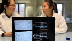 PhD students Yu Hou (left) and Yuko Bando (right) discuss the calcium response of the algal cells, which is visible on the screen as a peak after administration of synthetic orfamide A.