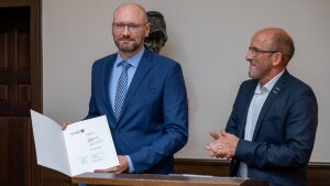 Prof. Dr. Michael Wessel (l.) ist zum Professor für E-Commerce ernannt worden. Vizepräsident Prof. Dr. Georg Pohnert (r.) überreicht die Ernennungsurkunde.