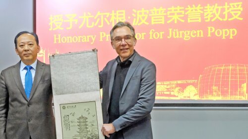 Prof. Dr. Jürgen Popp (r.) ist zum Ehrenprofessor der Wuhan Textile University (WTU) ernannt worden. Er nahm die Auszeichnung von WTU-Vizepräsident Feng Jun (l.) in Wuhan entgegen.