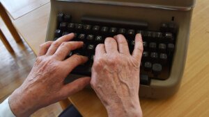 Hände auf einer Schreibmaschinentastatur.