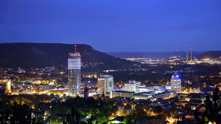 Der Campus Ernst-Abbe-Platz und das Universitätshauptgebäude bei Nacht.