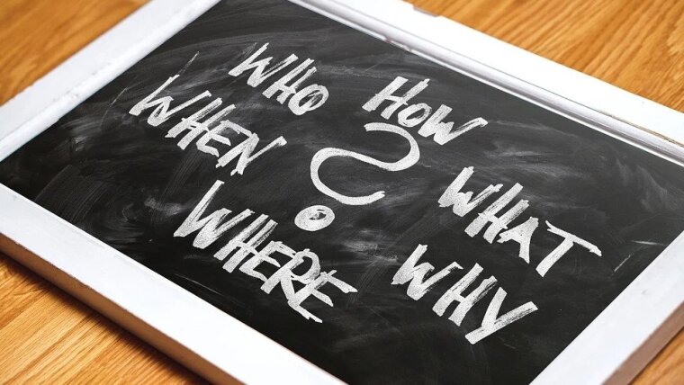 A tablet with "Who, How, What, Why, Where, When" written around a "?