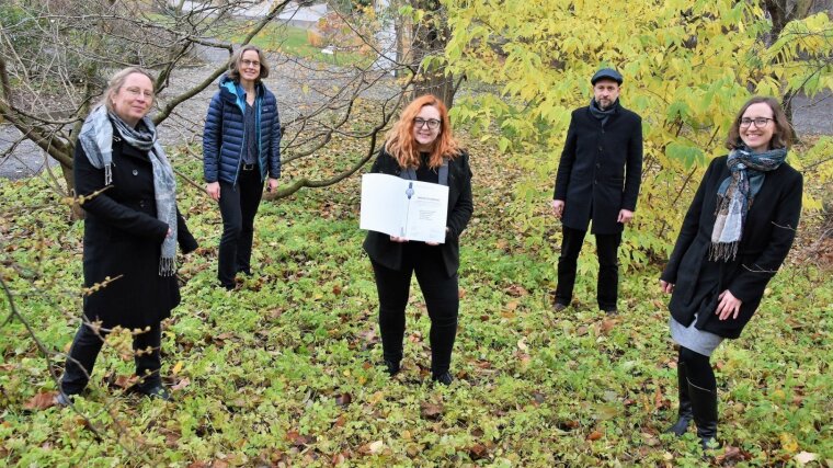 Gründungsmitglieder des Verbundes WKJ, stellvertretend durch 5 Personen, vor einer grünen Kulisse aufgestellt