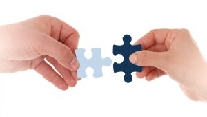 Hands fit together matching puzzle pieces
