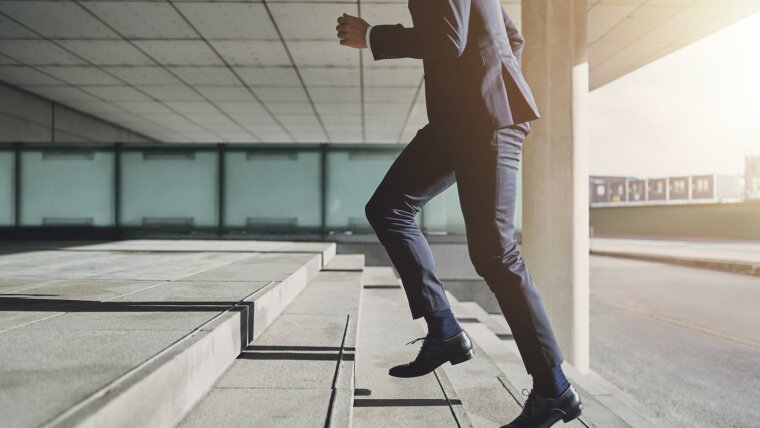 Man wearing suit runs up the stairs