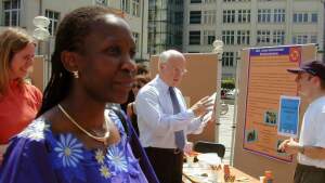 International women scientists on campus in front of information booths with research posters